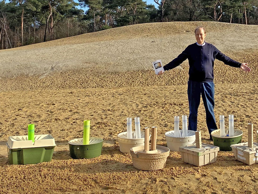 Man staat op een zandvlakte met meerdere waterboxxen